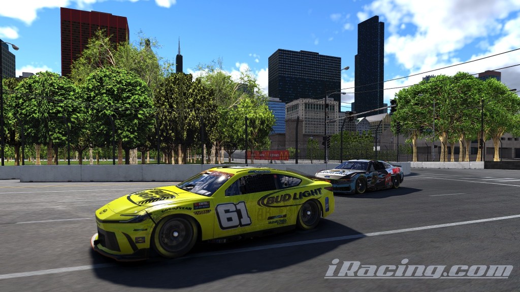 Two race cars navigating a corner on a city street circuit, with skyscrapers and trees in the background.