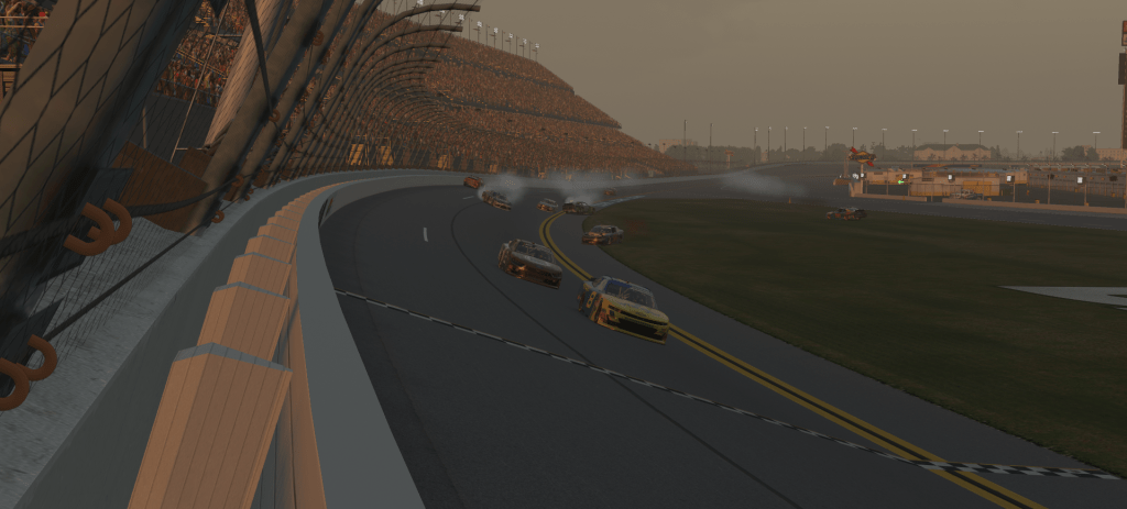 Cars involved in a multi-car crash on the track at Daytona International Speedway during a race, with smoke rising from several vehicles.