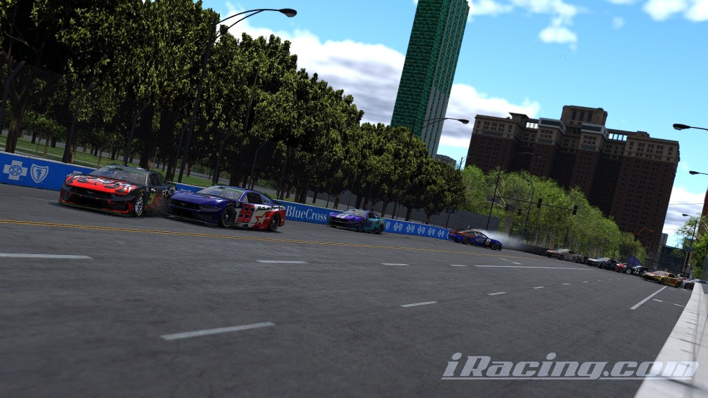 A scene from the Bonfire Premier Cup PRO/AM Series featuring race cars on a city street circuit in Chicago, with buildings and trees lining the road.