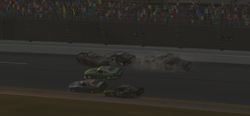 A collision among several race cars on the track at Daytona International Speedway, with a crowd visible in the stands.