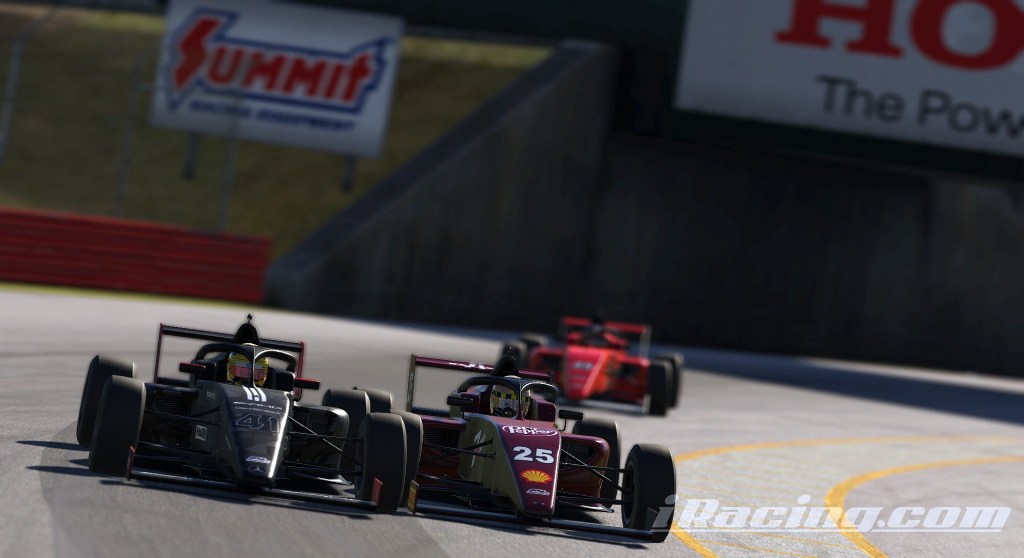 Two racing cars compete closely on a racetrack, with a third car in the background. The lead car is black and the second car is maroon.