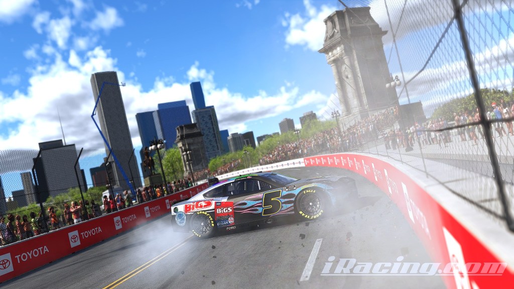 A race car collides with the wall during a race event in an urban setting, with spectators watching in the background.